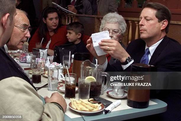 Democratic presidential candidate and US Vice President Al Gore discusses prescription drugs with Hazel and her husband Ken Woodruff at a diner in...