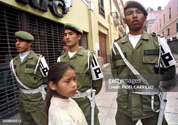 Girl passes in front of the military police 24 September 2000 in the center of Lima, Peru, during the celebration of Peruvian Armed Forces day....