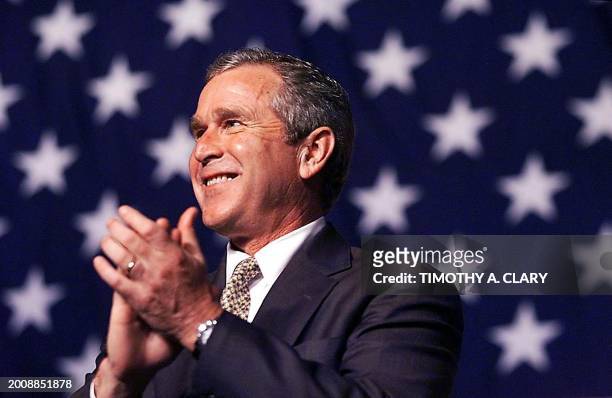Republican presidential candidate George W. Bush applauds as he waits to speak at a rally at Missouri State University 28 July 2000 in Joplin, MO....