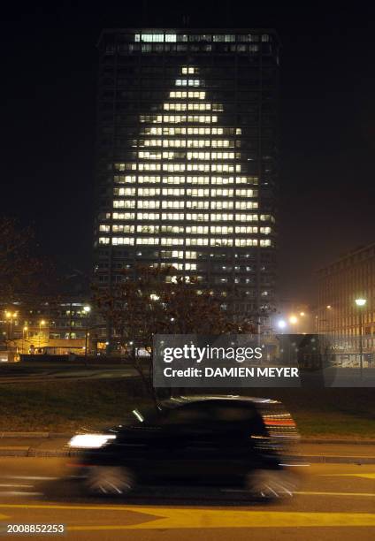 An office building leaves lights on in certain rooms to project the shape of a Chrtistmas tree in central Milan on December 7, 2008. AFP PHOTO/DAMIEN...