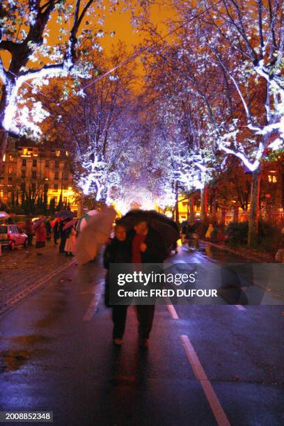 Des personnes se promènent 08 décembre 2006 dans les rues de Lyon illuminées à l'occasion de la 8e Fête des Lumières. Quatre millions de personnes...