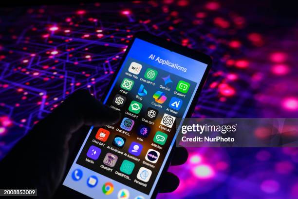 An AI-powered app icon, similar to those of Bing, Gemini, OpenAI, Chatbot, and Copilot, is being displayed on a smartphone among other applications...
