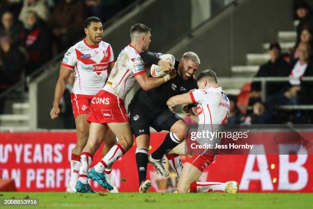 Hakim Miloudi of London Broncos is tackled by Lewis Dodd and Mark Percival of St.Helens during the Betfred Super League match between St Helens and...