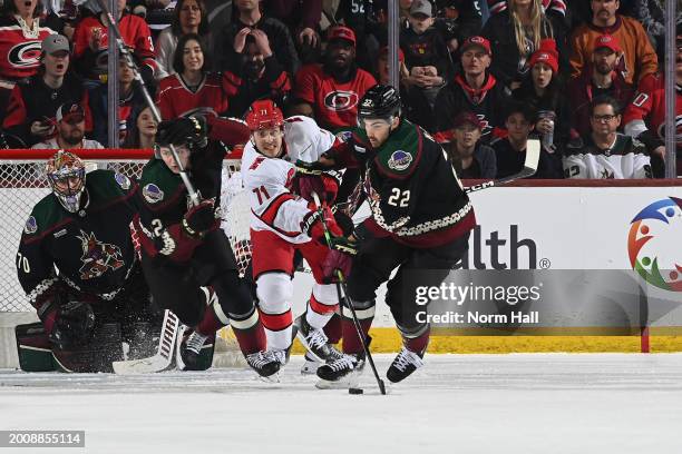 Jack McBain of the Arizona Coyotes skates with the puck while being defended by Jesper Fast of the Carolina Hurricanes during the first period of the...