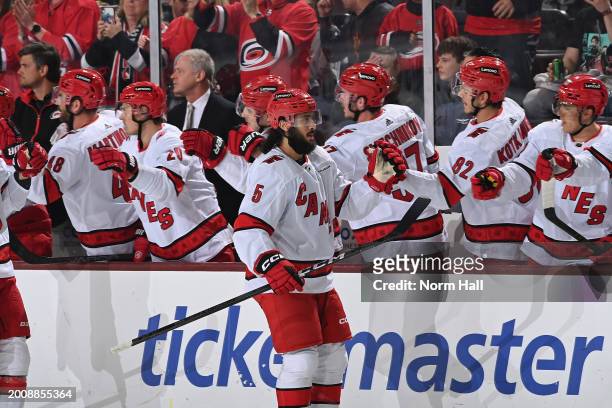 Jalen Chatfield of the Carolina Hurricanes celebrates with teammates on the bench after scoring a goal against the Arizona Coyotes during the first...