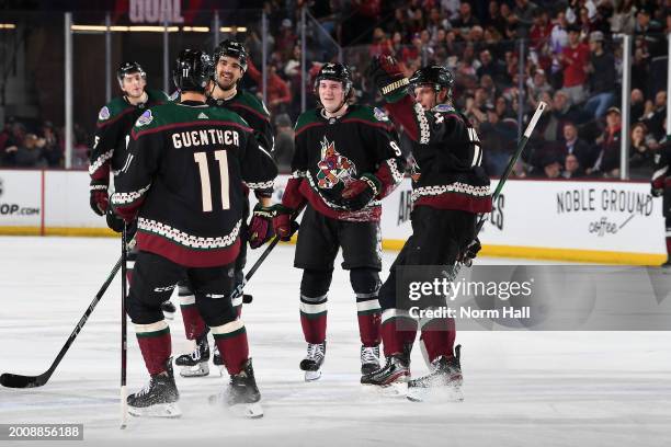 Dylan Guenther of the Arizona Coyotes celebrates with Jack McBain, Juuso Valimaki and teammates after scoring a goal against the Carolina Hurricanes...