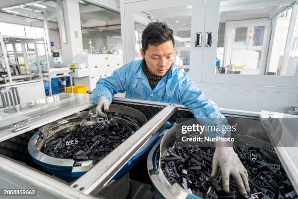 Worker is producing photovoltaic junction boxes and power station interconnection products at a workshop of an electrical appliance company in...