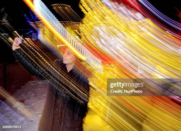 Person is taking a selfie near an illuminated bear figure in Gage Park in downtown Brampton, Ontario, Canada, on February 16, 2024.