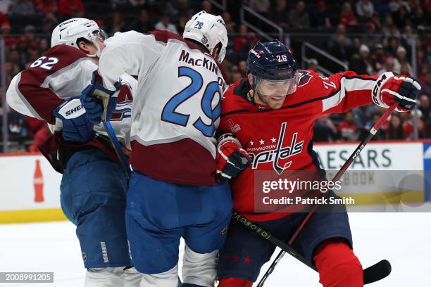 Nic Dowd of the Washington Capitals checks Nathan MacKinnon and Artturi Lehkonen of the Colorado Avalanche during the first period at Capital One...