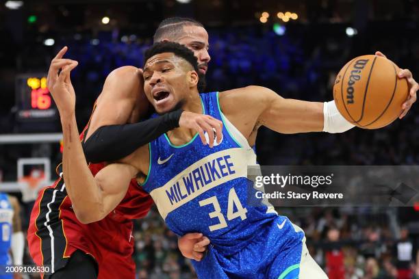 Giannis Antetokounmpo of the Milwaukee Bucks is fouled by Caleb Martin of the Miami Heat during the first half of a game at Fiserv Forum on February...