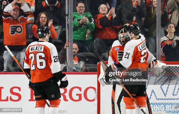 Scott Laughton, Sean Walker and Samuel Ersson of the Philadelphia Flyers celebrate after defeating the Winnipeg Jets 4-1 at the Wells Fargo Center on...