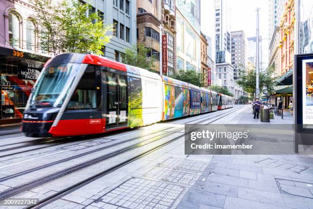 light rail tram traveling in city street, background with copy space - lightrail stock pictures, royalty-free photos & images