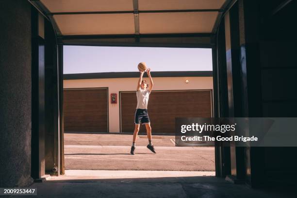 teenage boy playing basketball on sunny day - malibu home stock pictures, royalty-free photos & images