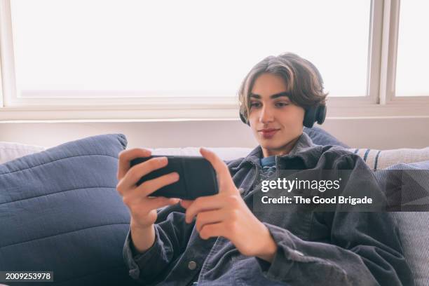 teenage boy watching video on smart phone - malibu home stock pictures, royalty-free photos & images