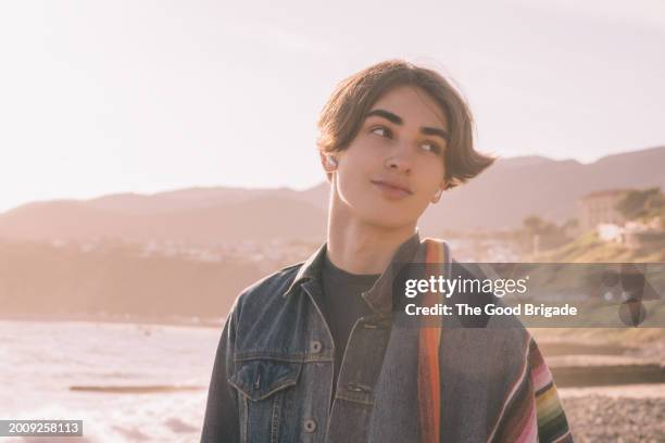 teenage boy standing at beach during sunset - malibu nature stock pictures, royalty-free photos & images