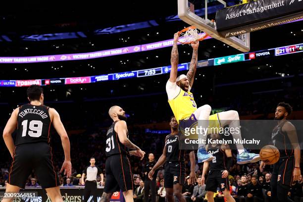 Anthony Davis of the Los Angeles Lakers dunks the ball against Simone Fontecchio, Evan Fournier, Jalen Duren, Cade Cunningham and Troy Brown Jr. #7...