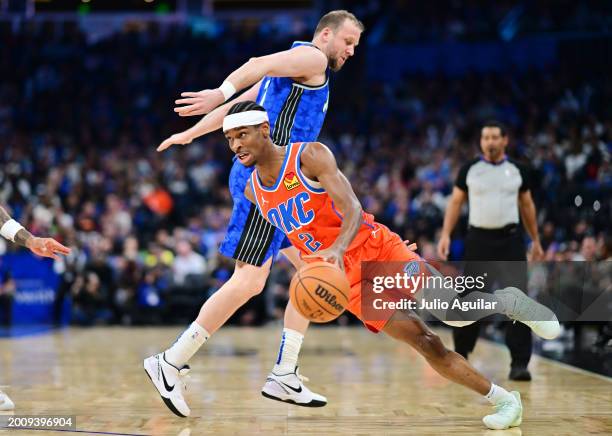 Shai Gilgeous-Alexander of the Oklahoma City Thunder drives around Joe Ingles of the Orlando Magic in the second half at Kia Center on February 13,...