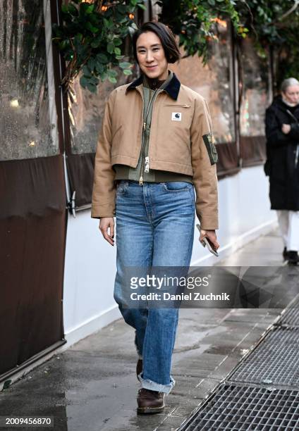 Eva Chen is seen wearing a Sacai x Carhartt jacket, blue jeans and brown shoes outside the Michael Kors show during NYFW F/W 2024 on February 13,...