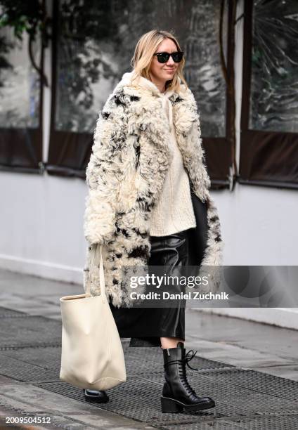 Lisa Aiken is seen wearing a black and white faux fur coat, cream top, black skirt and black boots with black sunglasses outside the Michael Kors...