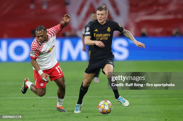 Lois Openda of RB Leipzig and Toni Kroos of Real Madrid CF compete for the ball during the UEFA Champions League 2023/24 round of 16 first leg match...