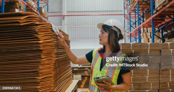une jeune ouvrière d’entrepôt asiatique vérifie le stock et l’inventaire avec une tablette numérique dans l’entrepôt de l’usine. entreprise de l’industrie logistique. - tôle ondulée photos et images de collection