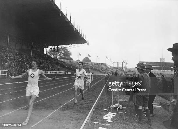 Swiss athlete Willy Scharer ahead of British athlete Douglas Lowe and American athlete William Spencer at the finish of the second semifinal of the...