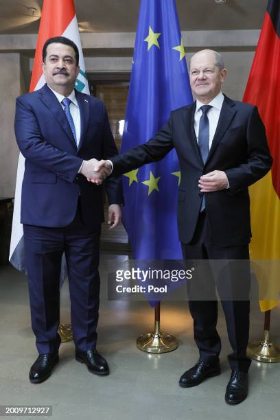 German Chancellor Olaf Scholz and Iraqi Prime Minister Mohammed Shia al-Sudani shake hands as they pose for media during bilateral talks at the...