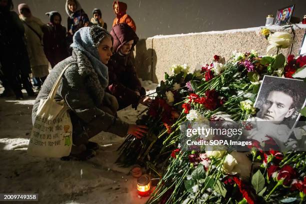 People lay flowers at a spontaneous memorial in memory of the deceased Russian opposition leader Alexei Navalny, organized at the monument to victims...