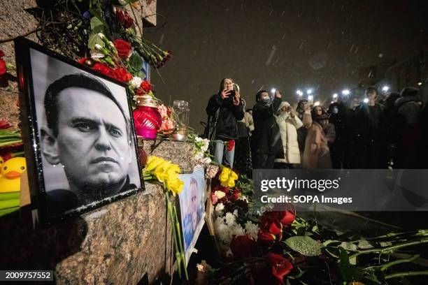 People flashlight at a spontaneous memorial in memory of the deceased Russian opposition leader Alexei Navalny, organized at the monument to victims...