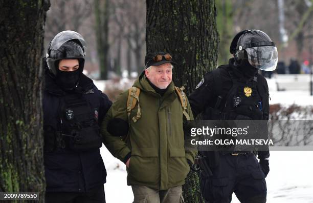 Police officers detain a man as people come to the monument to the victims of political repressions to lay flowers for late Russian opposition leader...