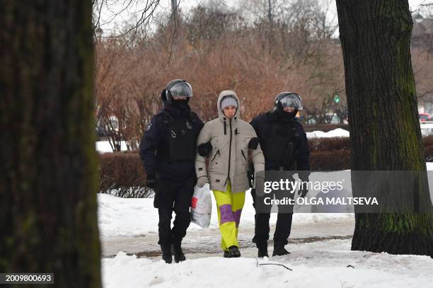 Police officers detain a man as people come to the monument to the victims of political repressions to lay flowers for late Russian opposition leader...