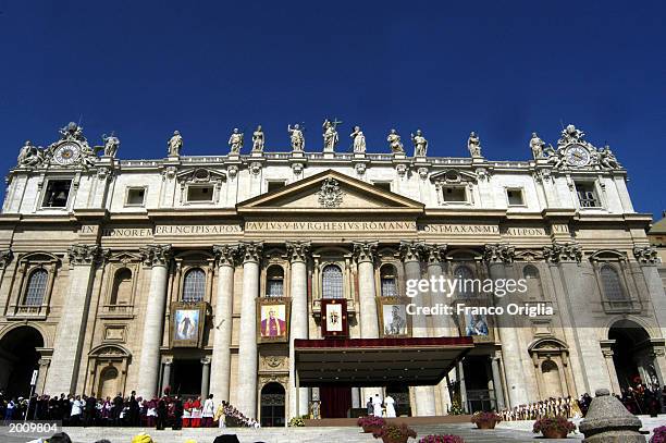 Tapestries depicting four new saints canonized by Pope John Paul II hang on the facade of St. Peter's Basilica during a special mass May 18, 2003 in...