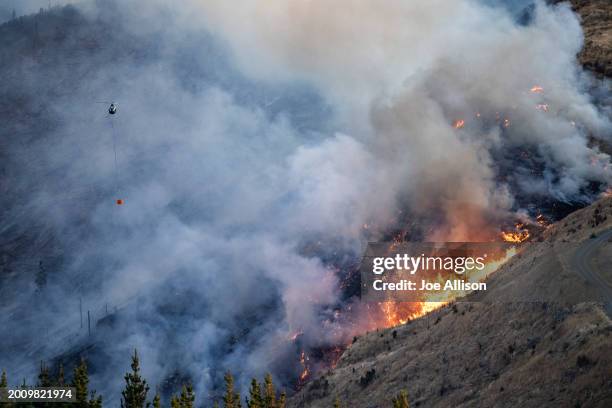 Helicopter works on extinguishing the fire at the Port Hills on February 14, 2024 in Christchurch, New Zealand. Residents were evacuated as fire...