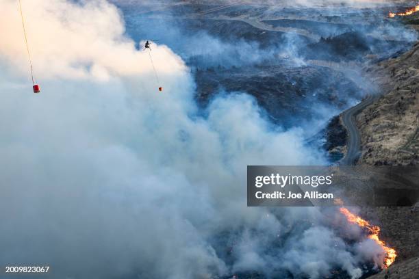 Helicopter works on extinguishing the fire at the Port Hills on February 14, 2024 in Christchurch, New Zealand. Residents were evacuated as fire...