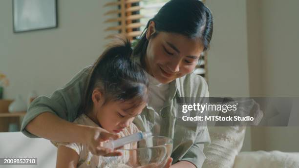 closeup of mom takes care of her daughter who gets sick and has a high fever, cold, and flu, and does nasal irrigation at home. illness girl with a medical condition and family wellness. - 生理食塩水 ストックフォトと画像