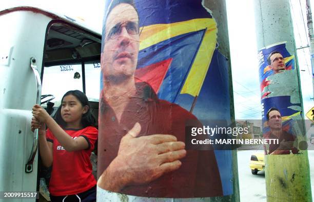 Girl sits in a truck behind a campaign poster of presidential candidate Alvaro Uribe in Soacha near Bogota, Colombia 25 May 2002. PHOTO MARTIN...