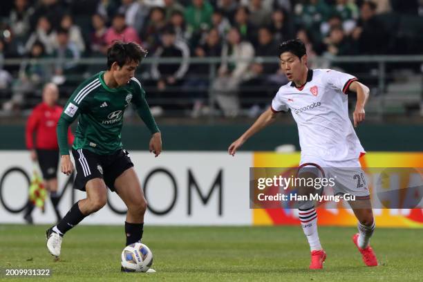 Song Min-kyu of Jeonbuk Hyundai Motors takes on Park Chan-yong of Pohang Steelers during the AFC Champions League Round of 16 first leg match between...