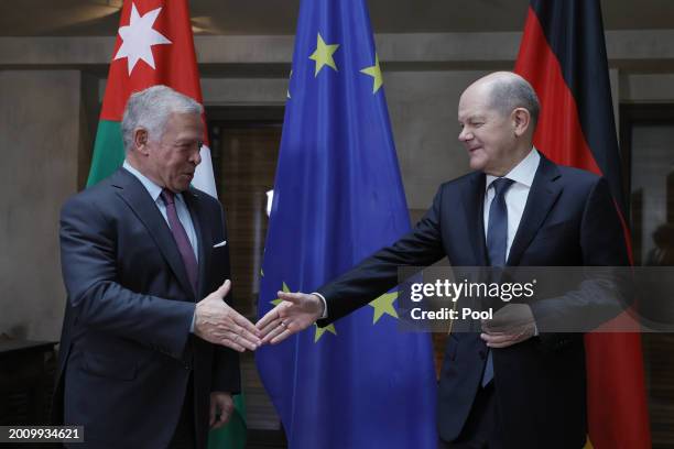 German Chancellor Olaf Scholz and King Abdullah II of Jordan shake hands as they pose for the media during bilateral talks at the 'Bayerischer Hof'...