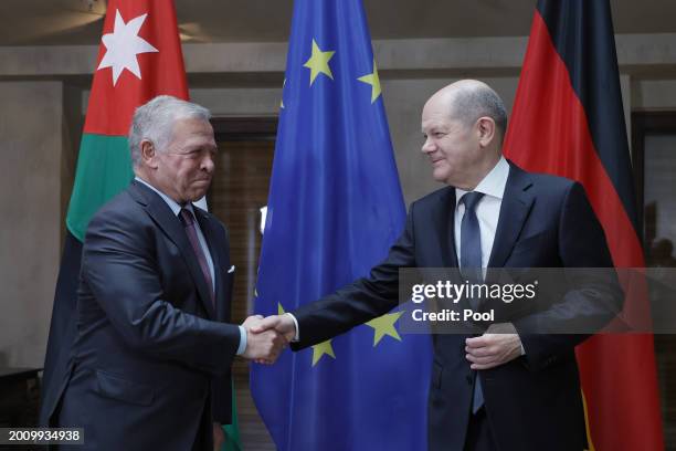 German Chancellor Olaf Scholz and King Abdullah II of Jordan shake hands as they pose for the media during bilateral talks at the 'Bayerischer Hof'...