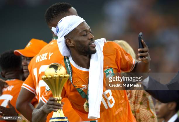 Ibrahim Sangare of Ivory Coast take a selfie with Africa Cup of Nations trophy on the podium after Ivory Coast won the Africa Cup of Nations 2024...