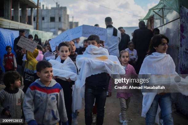 Palestinian children march during a protest demanding an end to the war and their right to live, education and play on February 14, 2024 in Rafah,...