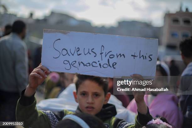 Palestinian children hold placards during a march demanding an end to the war and their right to live, education and play on February 14, 2024 in...