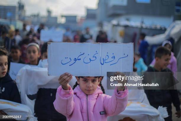 Palestinian children hold placards during a march demanding an end to the war and their right to live, education and play on February 14, 2024 in...