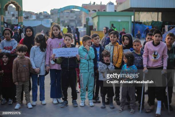 Palestinian children hold placards during a march demanding an end to the war and their right to live, education and play on February 14, 2024 in...