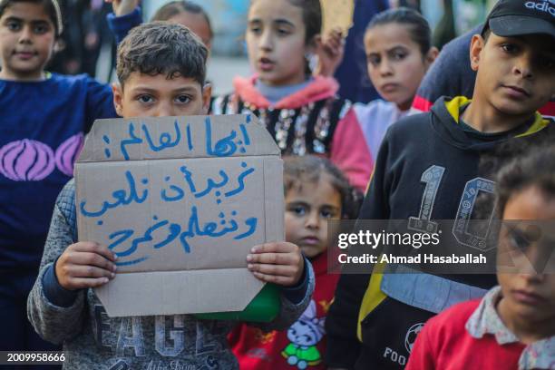 Palestinian children hold placards during a march demanding an end to the war and their right to live, education and play on February 14, 2024 in...