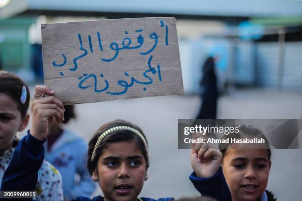 Palestinian children hold placards during a march demanding an end to the war and their right to live, education and play on February 14, 2024 in...