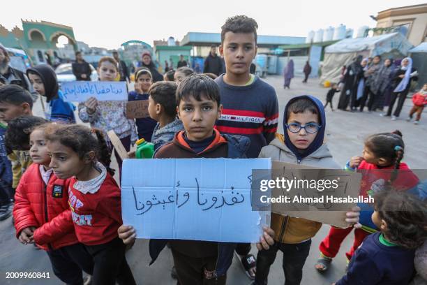 Palestinian children hold placards during a march demanding an end to the war and their right to live, education and play on February 14, 2024 in...