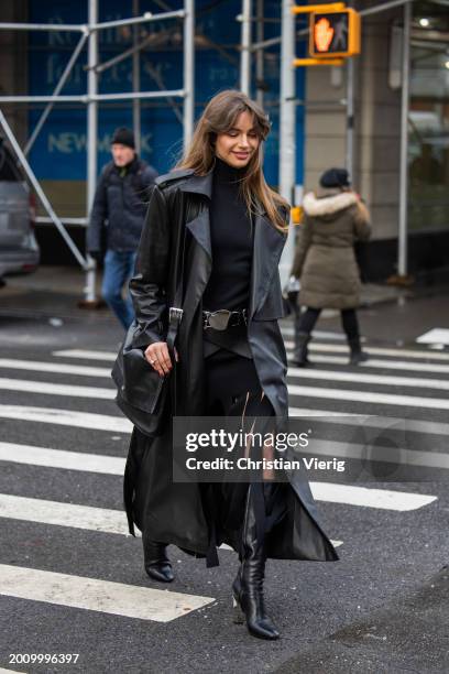 Mara Lafontan wears black coat, turtleneck, skirt with slit, bag, knee high boots outside Michael Kors on February 13, 2024 in New York City.