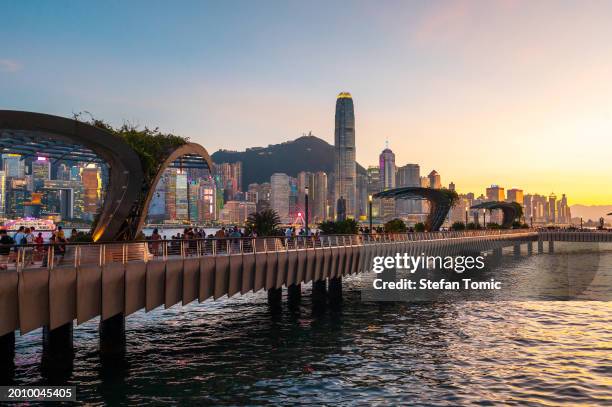 ligne d’horizon de hong kong avec un pont au-dessus de l’eau avec une ville en arrière-plan au port de victoria - ligne dhorizon au dessus de leau photos et images de collection