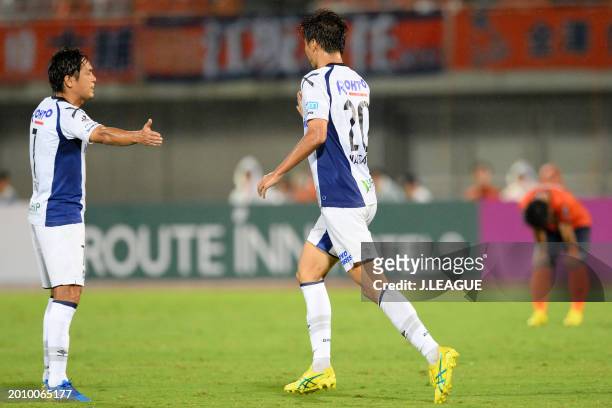 Shun Nagasawa of Gamba Osaka celebrates with teammate Yasuhito Endo after scoring the team's second goal during the J.League J1 match between Omiya...